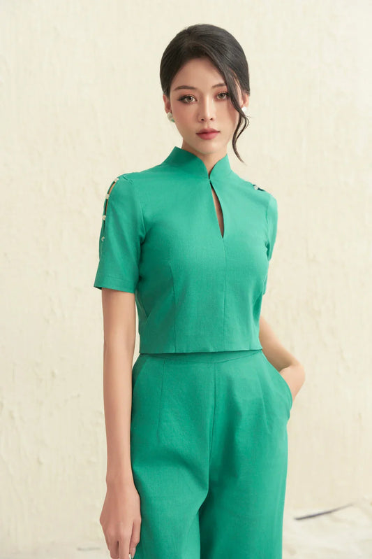 Woman wearing modern green cheongsam jumpsuit with mandarin collar and side buttons