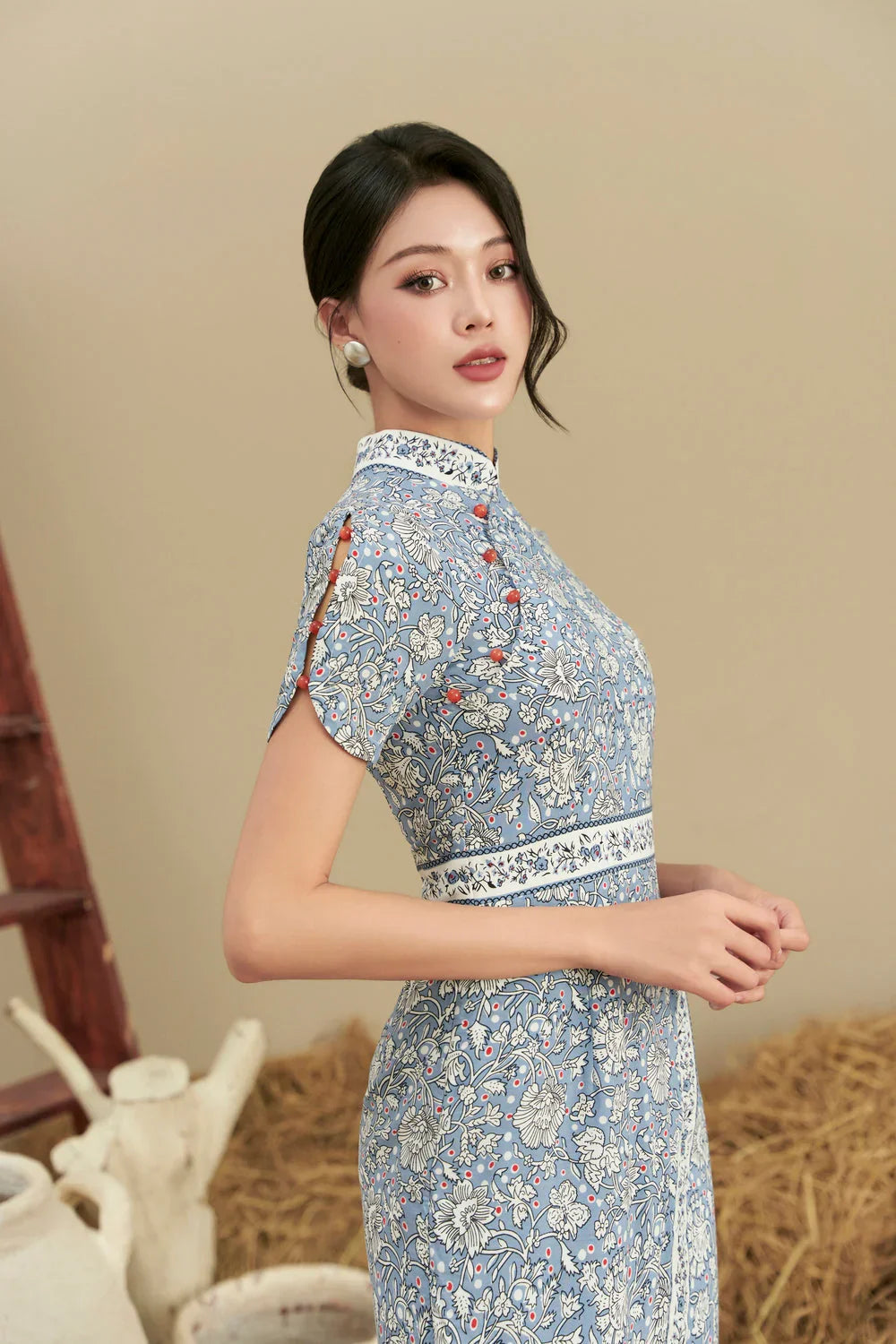 Woman wearing blue floral modern cheongsam dress with mandarin collar and cap sleeves