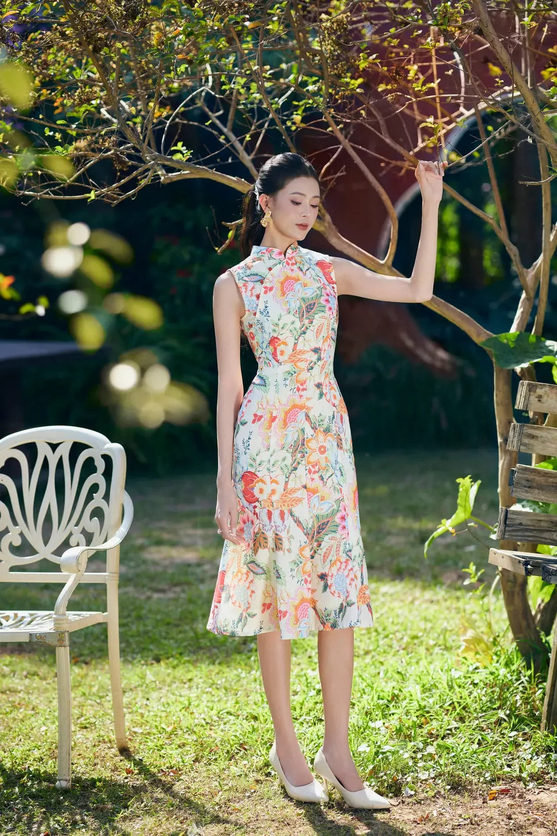 Woman wearing sleeveless floral cheongsam dress standing in a garden, elegant occasion wear