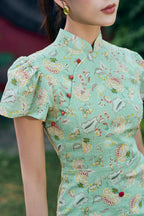 Woman wearing a mint green floral cheongsam dress with cap sleeves and red buttons