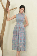 Woman in sleeveless floral modern cheongsam dress with fitted waist, standing indoors