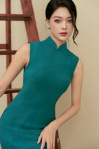 Woman in teal modern cheongsam dress with textured pattern, posing indoors by a wooden ladder