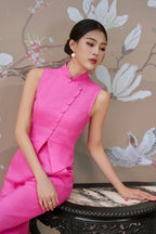 Woman in a modern hot pink sleeveless cheongsam with mandarin collar, floral background