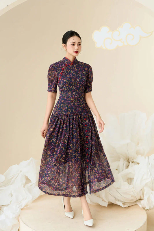 Woman in a modern navy floral cheongsam dress with puff sleeves and mandarin collar standing indoors