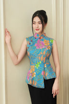Woman wearing modern sleeveless floral cheongsam with blue, orange, and pink patterns
