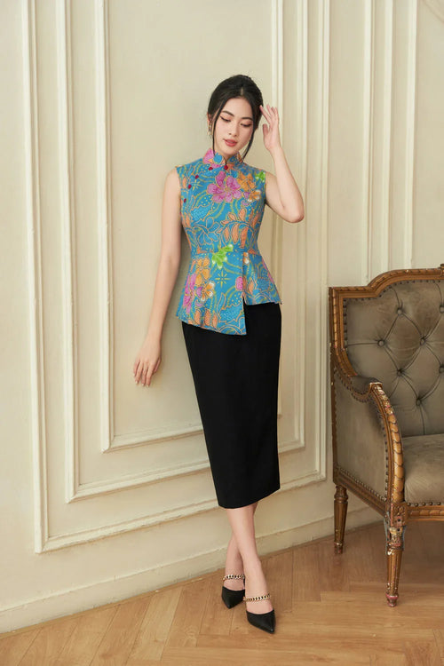 Woman wearing a modern cheongsam with blue floral top and black skirt in elegant room