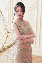 Woman in elegant pink floral lace cheongsam dress standing by crystal chandelier